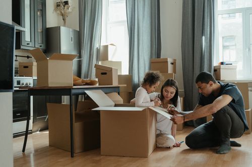Movers wrapping furniture with moving blankets